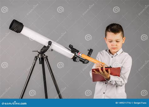 Young Astronomer Looks Through A Telescope And Writes In The Tablet