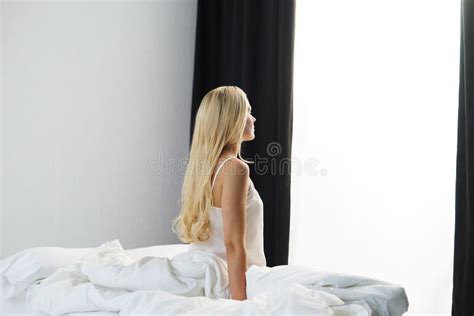 Young Woman In The Bed Beautiful Blond Girl Wakes Up Morning In The Bedroom Daylight From The