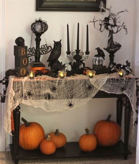 A Halloween Table With Candles And Decorations On It