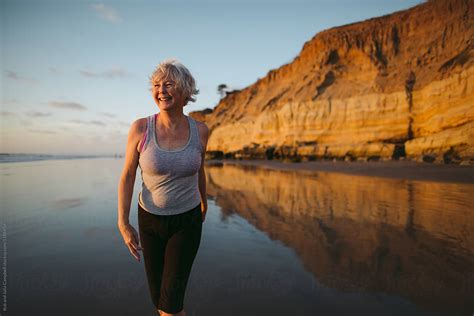 Vibrant Mature Woman Enjoying Herself On The Beach At Sunset Del