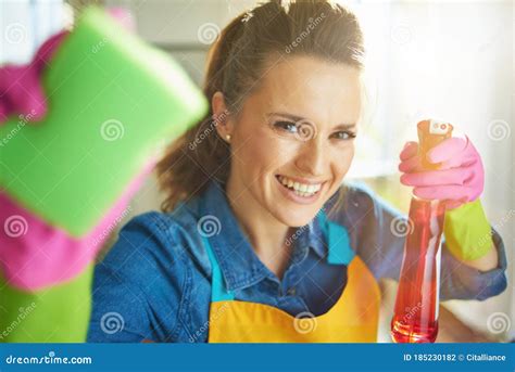 Female With Cleaning Agent And Sponge Doing Household Work Stock Photo