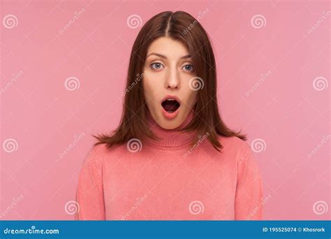 closeup extremely shocked bemused brunette woman looking at camera with big eyes and widely