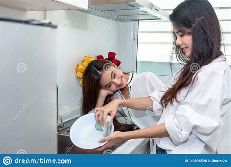 Two Asian Women Washing Dishes Together In Kitchen People And Lifestyles Concept Zdj Cie Stock
