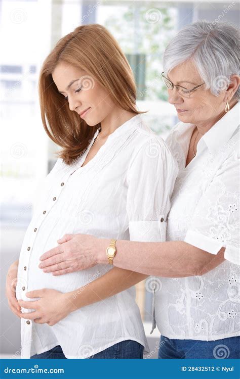 Madre Mayor Que Abraza La Sonrisa Embarazada De La Hija Fotografía De