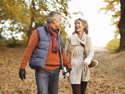 Older Couple Walking Together In Park Stock Photo