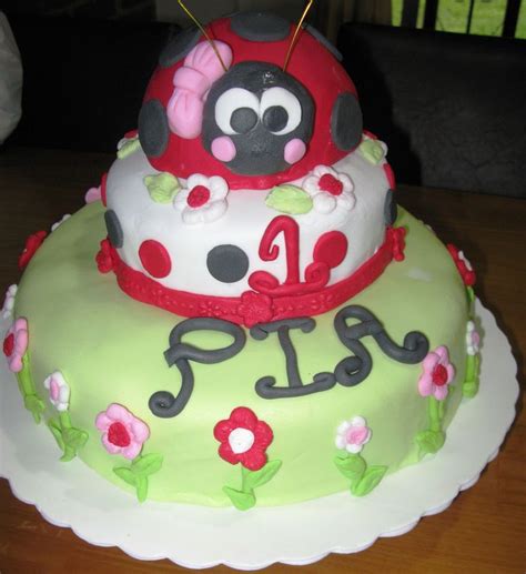 A Birthday Cake With A Ladybug Decoration On The Top And Number One On