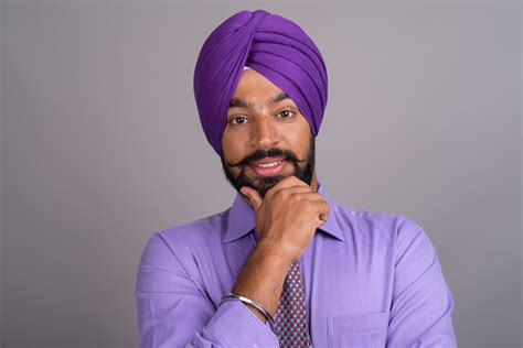 Studio Shot Of Young Indian Sikh Businessman Wearing Purple Shirt With