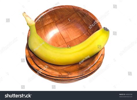 A Fresh Banana Sitting In A Wooden Bowl At The Top Of A Stack Of Bowls