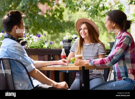 Young People Talking At Cafe Table Stock Photo Alamy