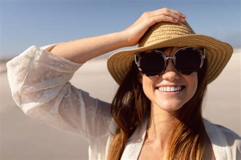 Free Photo Beautiful Woman In Hat And Sunglasses Standing On Beach In