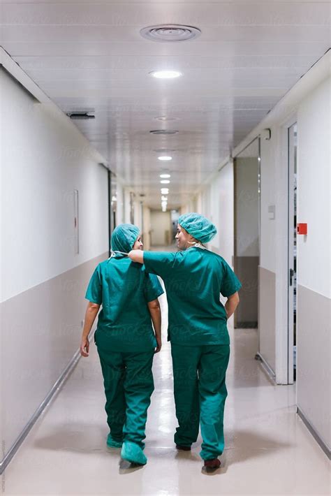 Surgeons Walking Through A Hospital Corridor By Victor Torres Medical