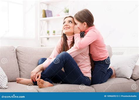 Mother With Her Cute Little Daughter Sitting On The Sofa Stock Image