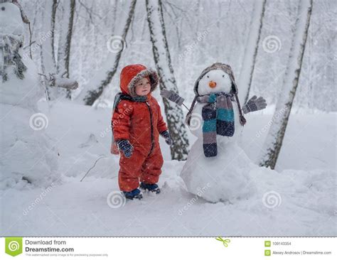 European Boy And The Snowman In A Snowy Forest Stock Photo Image Of
