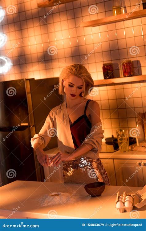 belle femme au foyer avec de la farine sur le compteur faisant cuire dans la cuisine image stock