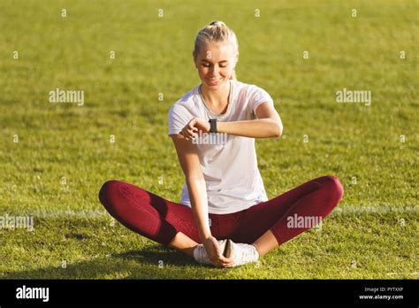fitness blonde long haired woman in sportswear sitting in the lotus pose and looking on the