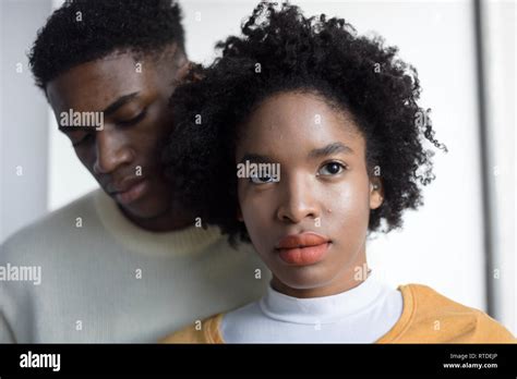 A Young Attractive Black Couple Looking Serious In A Simple White Room Modern Fashionable