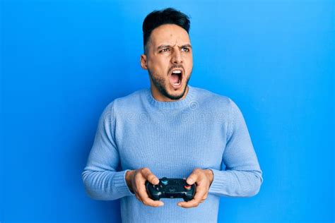 Young Arab Man Playing Video Game Holding Controller Angry And Mad