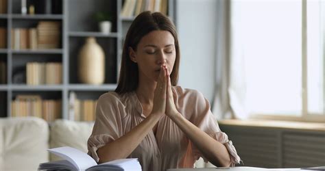 Young Faithful Mindful Woman Praying With Closed Eyes At Home Stock