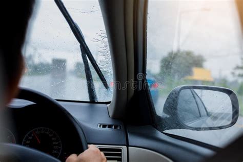 Selective Focus To Man Driving A Car With Rain Droplet On Windshield
