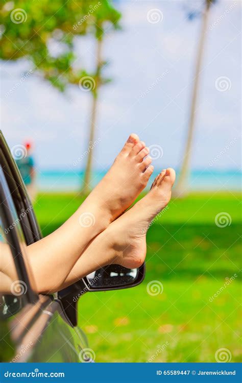 Bare Feet Of Female Sticking Out Car Window By Ocean Stock Image