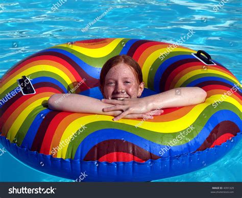 Red Haired Girl Child In A Swimming Pool With A Brightly Coloured