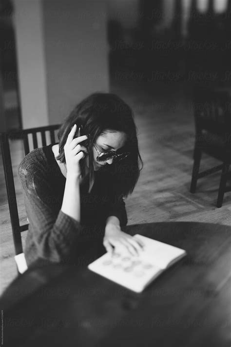 Young Woman Sitting In A Coffee Shop And Reading A Book Del