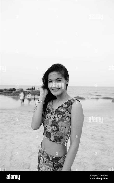 Young Happy Asian Woman Smiling While Fixing Her Hair At The Public Beach Of Hua Hin In Thailand