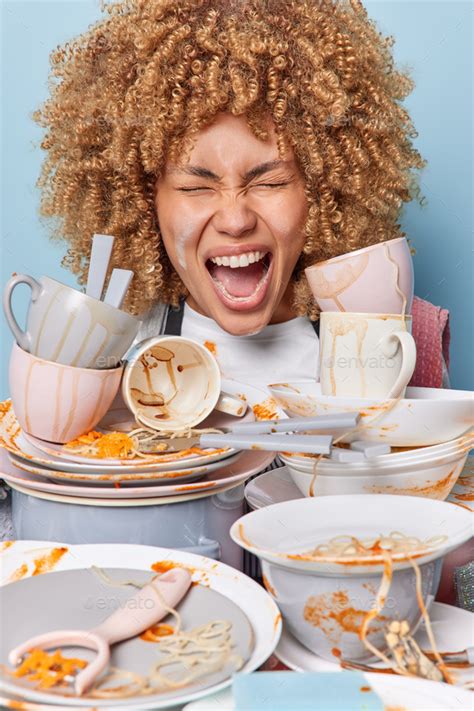 Emotional Curly Haired Woman Screams Loudly With Widely Opened Mouth