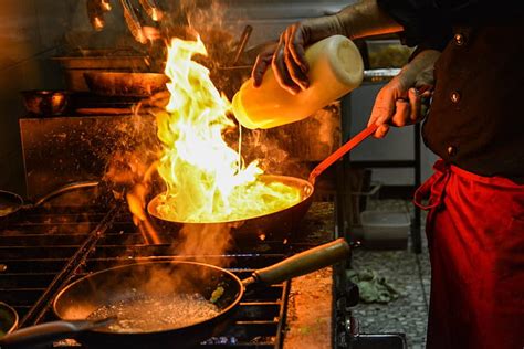 Royalty Free Photo Person Cooking On Black Frying Pan With Fire On Top