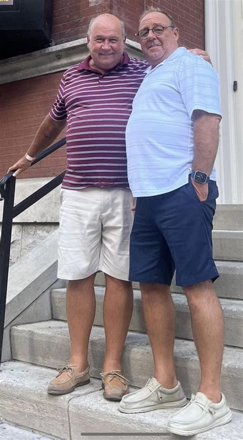 Two Men Standing On Steps With Their Arms Around Each Other