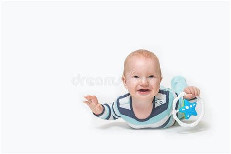 Laughing Baby Boy Is Lying On White Background Holding A Toy Stock