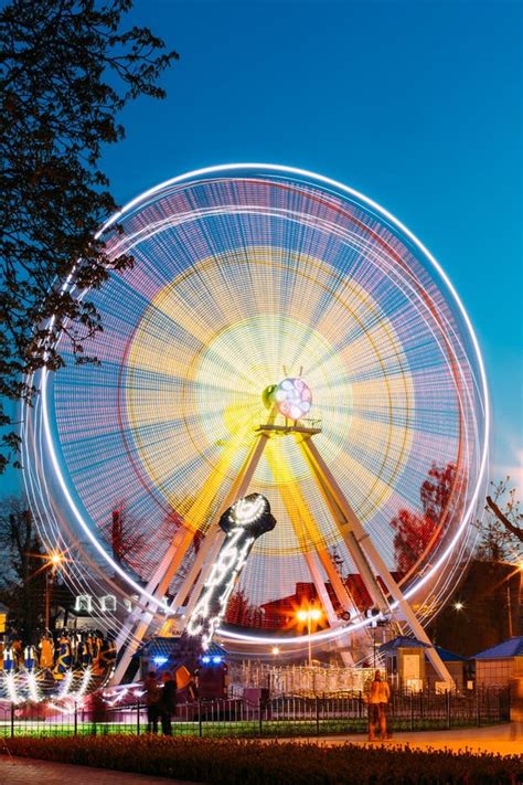 Illuminated Attraction Ferris Wheel On Summer Evening In City Amusement