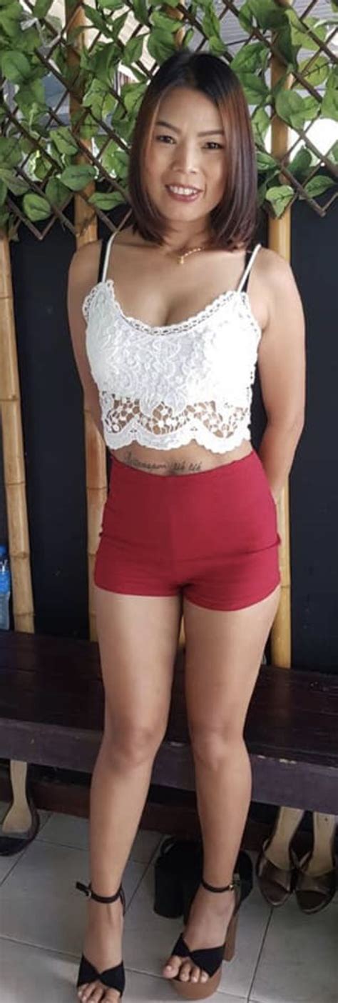 A Woman In Red Shorts And White Top Posing For The Camera With Her