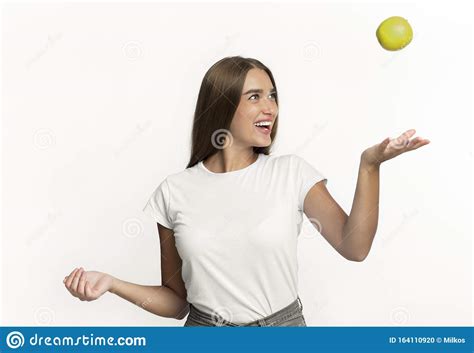 Chica Arrojando A Apple En El Aire De Fondo Blanco Foto De Archivo