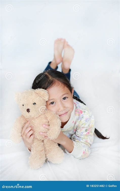 Portrait Of Happy Asian Little Child Girl Hugging Brown Teddy Bear