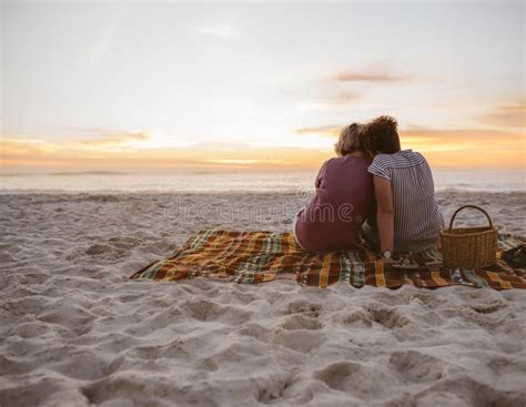 Young Lesbian Couple Sitting On Beach Blanket Watching The Sunset Stock Image Image Of