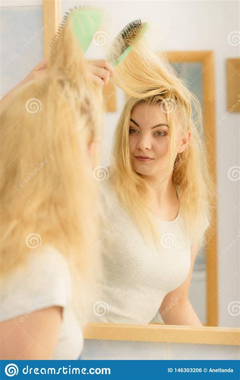 Woman Brushing Her Blonde Hair In Bathroom Stock Photo Image Of