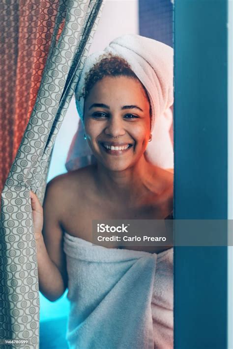 A Smiling Young African American Woman Exits The Shower In A Hotel