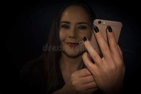 Female Hands Manipulating Mobile Phone To Take Selfie Of Her Face With Bokeh Effect At The End