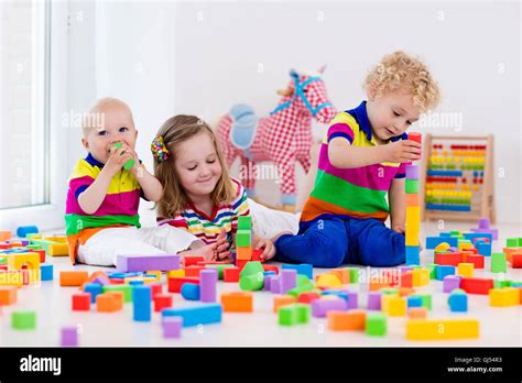 Happy Preschool Age Children Play With Colorful Plastic Toy Blocks