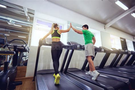 Personal Trainer Man With Athletic Girl On A Treadmill In The Gy Stock