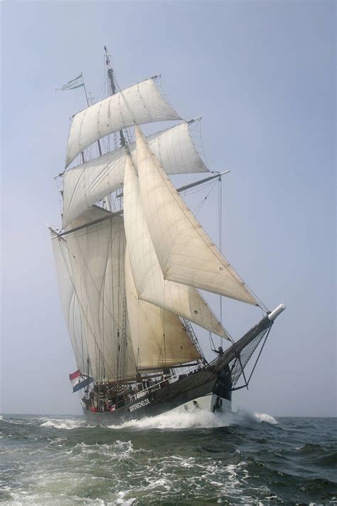 A Large White Sail Boat Sailing In The Ocean