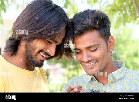 Happy Young Indian Gay Couple Looking At Their Photos On The Phone