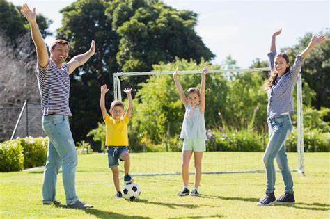 Familia Feliz Jugando Al Fútbol En El Parque Foto Premium