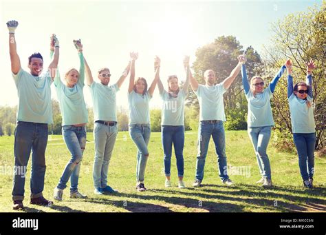 Group Of Happy Volunteers Holding Hands Outdoors Stock Photo Alamy