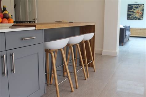 Three Stools Sit In Front Of A Kitchen Counter With Fruit On The