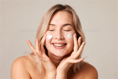 close up beauty portrait laughing beautiful half naked woman applying face cream make stock