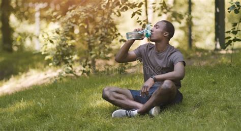 Black Guy Drinking Water Resting In Park On Grass Stock Image Image