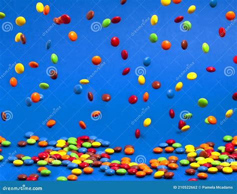 Rainbow Colored Candy Coated Chocolate Buttons Falling Into A Pile On A