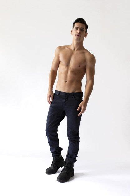 В полный рост молодой человек с нагнутым торсом в черных джинсах на белом Премиум Фото